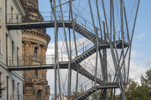  Bewusst vom Gebäude abgesetzt wirkt die Konstruktion durch den transparenten Stangen-Turm wie ein Solitär vor dem barocken Gebäude.  