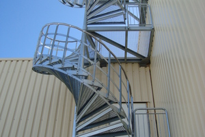  Dreigeschossige Spindeltreppe in feuerverzinkter Stahlbauweise als Zugang zum Techniktrakt und zum Hallendach zur Wartung und Begehung eines Industriegebäudes. 