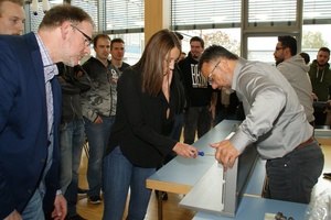  Schülerin Jasmin Jakobs stellte mit Unterstützung des Experten M. Klasen (r.) und unter Beobachtung der Lerngruppe mit Metalltechniklehrer Michael Höhler (l.) die Schließgeschwindigkeit des Türschließers ein. 