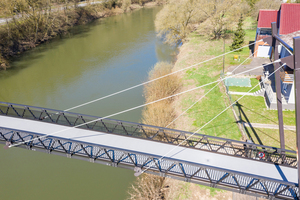  Der Überbau selbst ist eine durchlaufende Aluminium-Konstruktion aus vertikalen Fachwerkträgern, Querträgern, Sekundärträgern und Belagsplatten.  