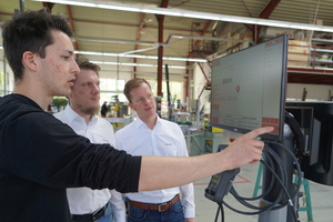  Die Außendienstler von Orgadata, Dominic Mann (m.) und Jörn Enk (r.), zeigen in der Werkstatt die Bedienung am Terminal. 