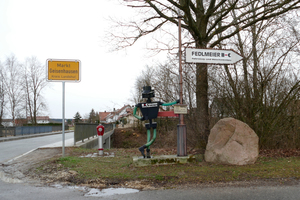  Vor dem Ortsschild weist ein stählerner Schornsteinfeger zum Betrieb Fedlmeier hin. 