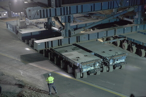  Das Einfahren der Brücke mit SPMTs. Die Arbeiter mit den Warnwesten steuern mit Funkfernsteuerungen einmal die vordere und einmal die hintere Einheit von je 8 zusammengeschalteten Fahrzeugen. 