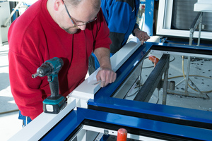  <div class="bildtext">Mitarbeiter von Klein Metallbau in Kempenich setzen das Lüftungssystem Endura Twist auf einen Alu-Fensterrahmen in der Werkstatt.</div> 