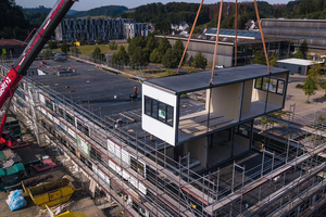  Im Werk gefertigte Raummodule werden auf die Baustelle gebracht. 