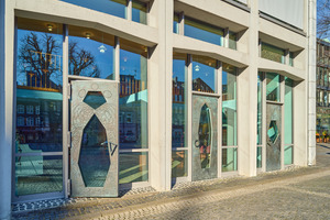 <div class="bildtext">Die Türen mit den Bronzeapplikationen führen unmittelbar in die Aula der Domsingschule. </div> 