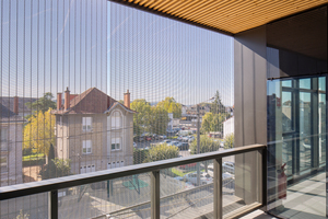  Das Fassadengewebe beeindruckt durch Ästethik, schützt die Menschen hinter der Glasfront vor der Sonne und lässt das Tageslicht in die Räume. 