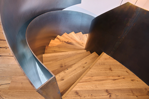  Die gerundete Holztreppe mit der gebogenen Form im Geländerschnitt&nbsp; fordert präzises Handwerk. 