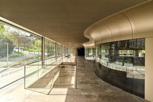 Im Kontrast zur geraden äußeren Structural Glazing Fassade steht die geschwungene Glaswand, die Foyer und Konzertsaal trennt. 