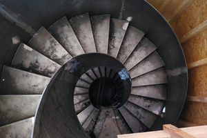  Blick von oben durch das Treppenauge der im Rohbau fertig montierten, zweigeschossigen Wendeltreppe. 