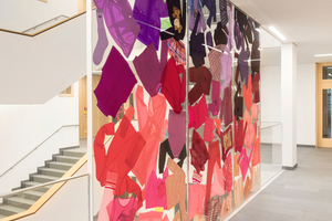  In der Grundschule Hermine-von-Parish in München wurden in die Glas-trennwände im Treppenhaus bunte T-Shirts und Hosen einlaminiert. 