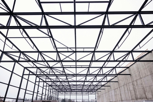  Für die Dachkonstruktion hob der Kran die Träger hochkant auf 14 Meter, wo die Fachwerke aus „Green Steel“mit Hebebühnen montiert wurden. 