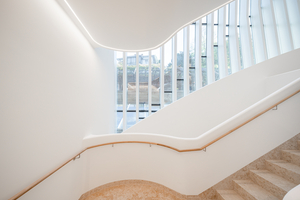  Das viergeschossige Atrium sowie das skulpturale Treppenhaus bilden das räumliche Herz des Gebäudes. 