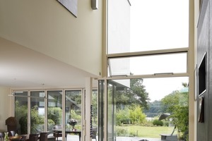  Die Wohnhalle mit Zutritt zur Terrasse und Blick auf den Plauer See: Automatisch gesteuerte Senkklappflügel und Dachluken sorgen für sommerliche Querlüftung. 