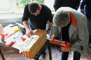  Schüler Hermann Voth (l.) mit dem Experten Roberto Weyda beim Setzen eines Injektionsankers in einen Hochlochziegel. 