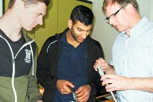  Die Schüler Andreas Adams (l) und Fadi Traini (m) im Fachgespräch mit Michael Höhler (r.) zur Konstruktion von Stahlseilen. 